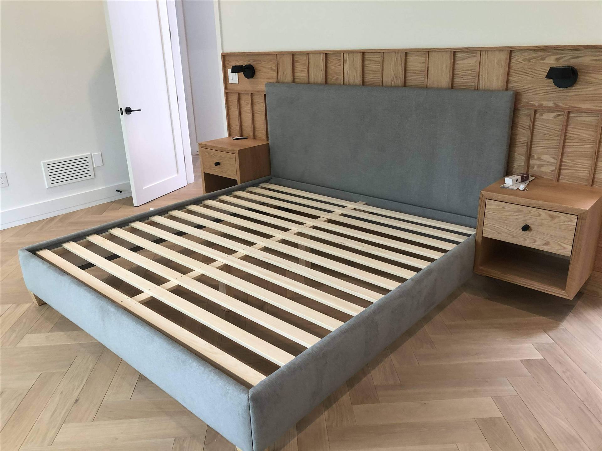 Custom grey velvet platform bed with oak slatted wall panel headboard
