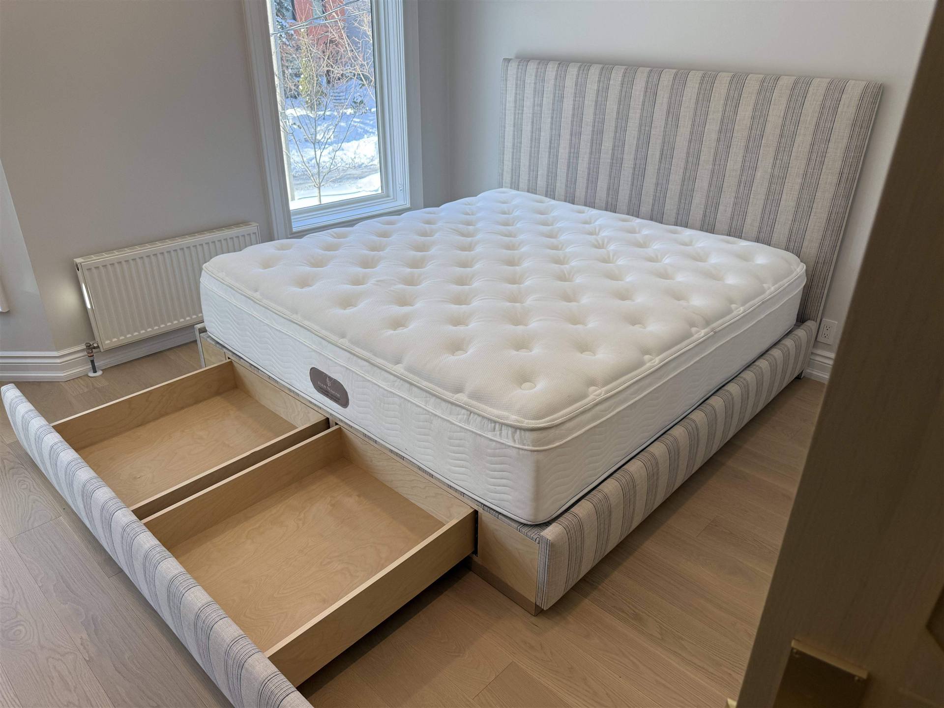 Custom stripe upholstered bed with pull-out storage drawers open
