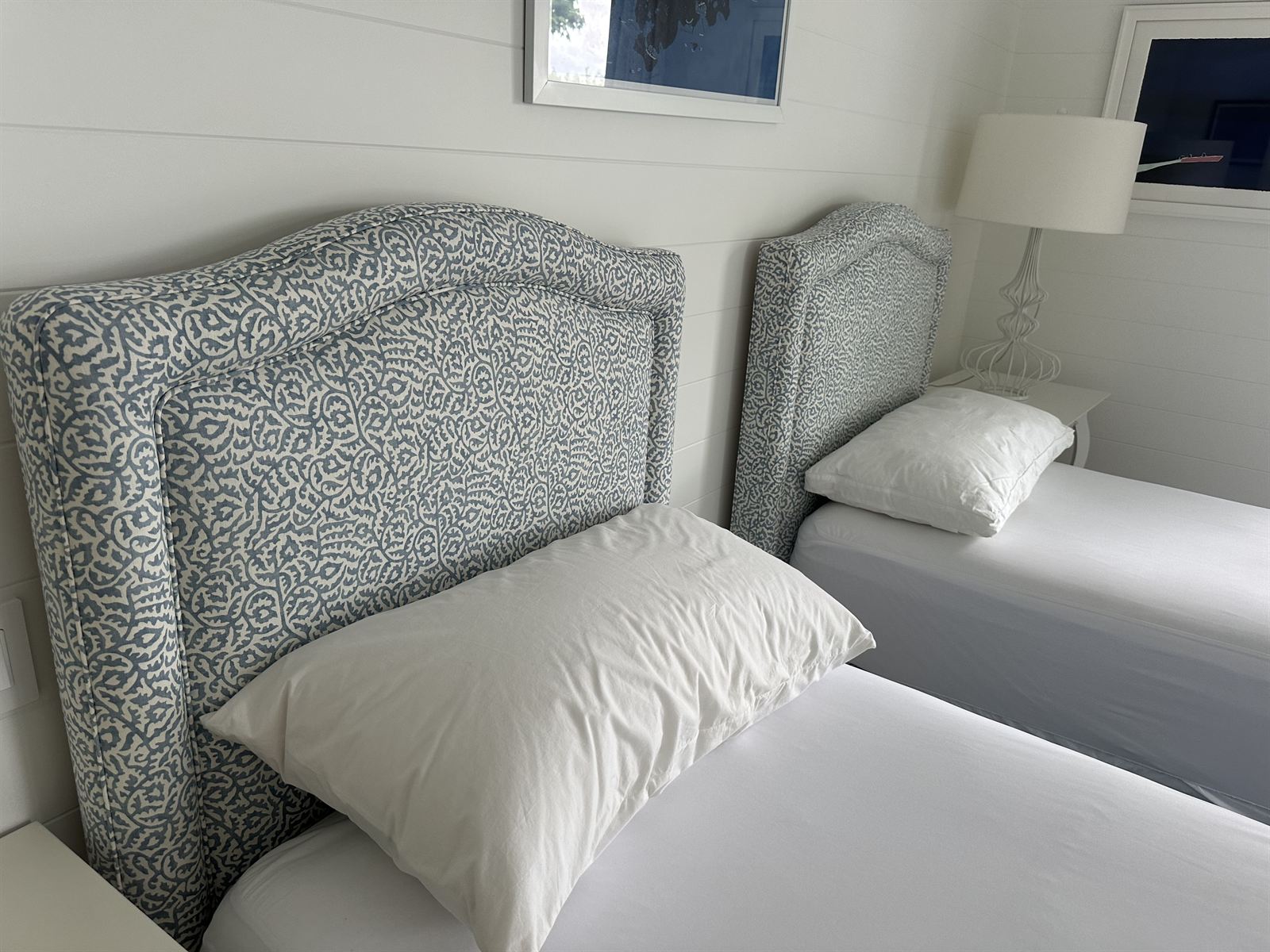 Custom blue and white patterned twin headboards with camelback arch and wingback sides
